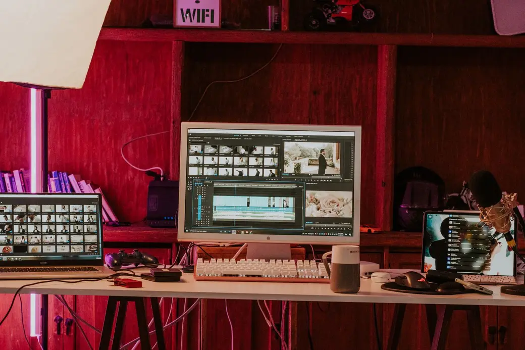 An editing desk with a video timeline on screen in a warm, colourful studio
