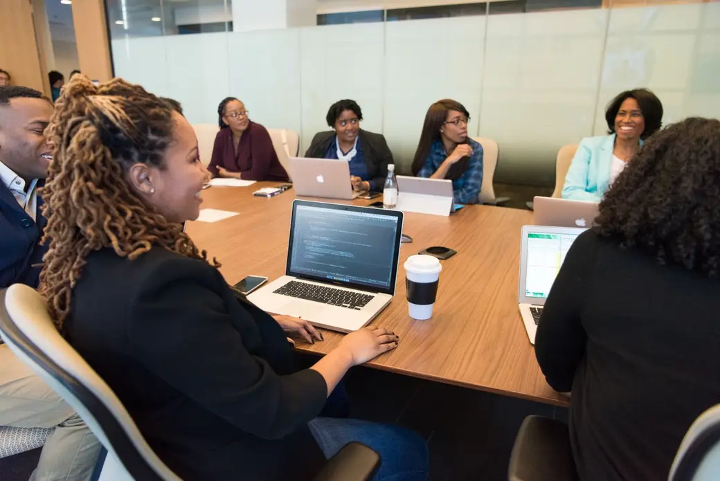 A team around a table with laptops, talking through their next steps