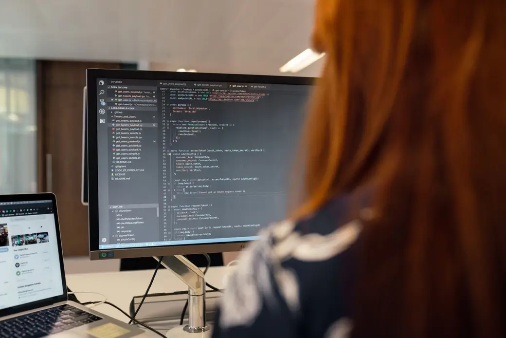 A developer working on code at a desk in a bright office