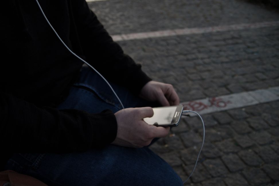hands holding smartphone listening