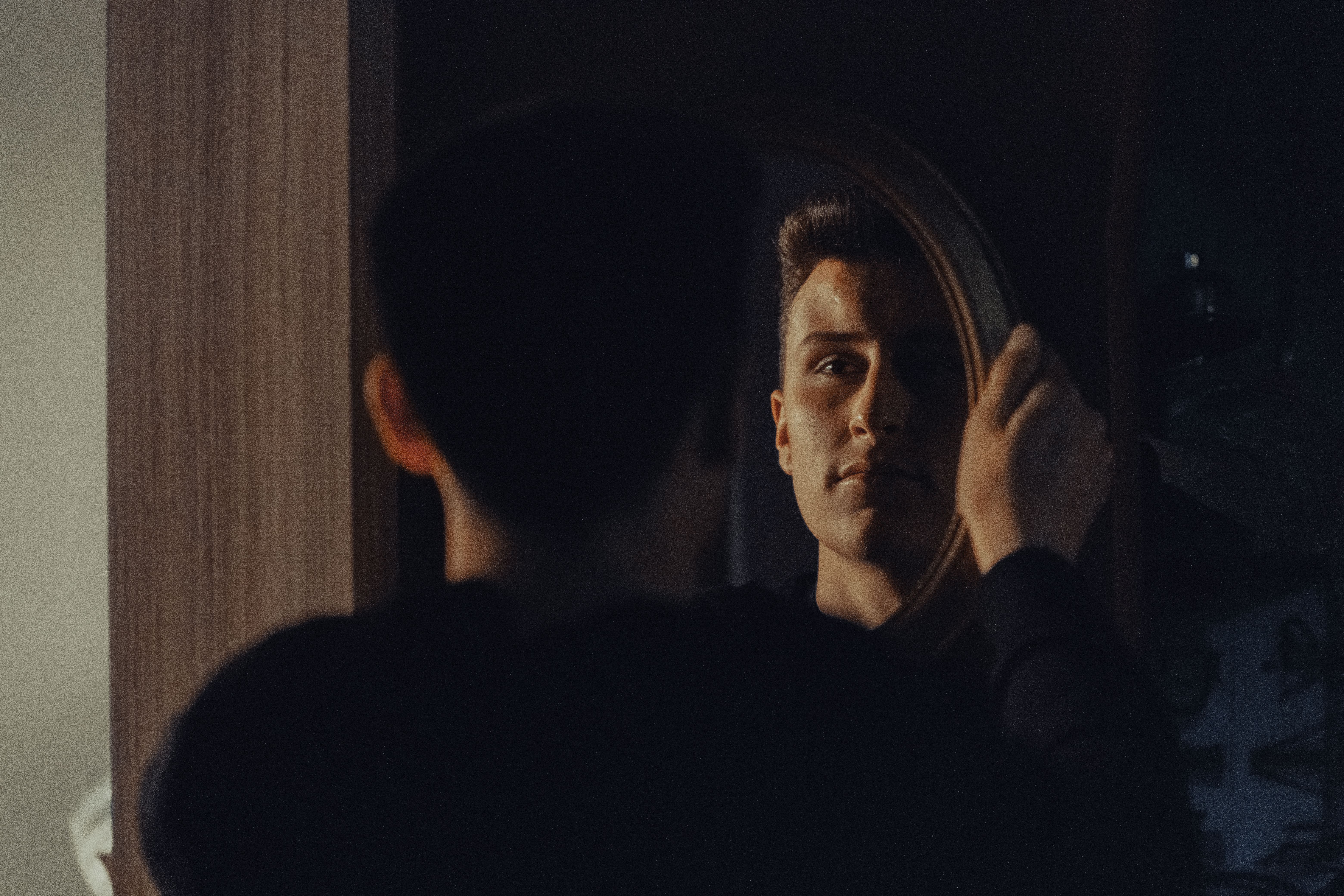 man looking at mirror reflection