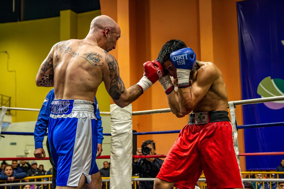Intense boxing match between two male fighters showcasing strength and skill.