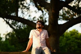 A young man in New Delhi enjoying the golden hour under a tree