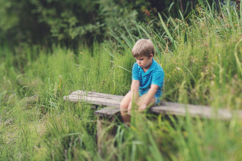 Child sitting alone outdoors