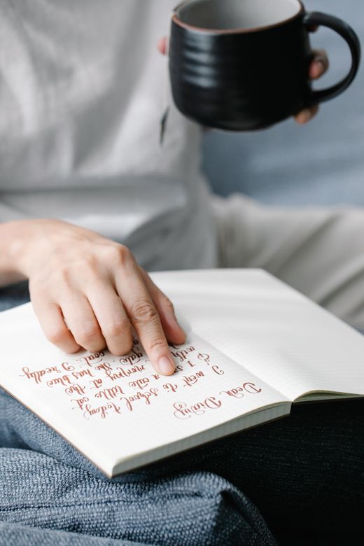 A hand resting on an open handwritten journal
